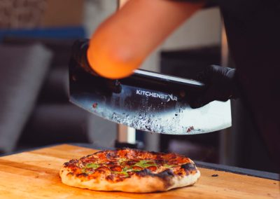 Pizza qui s'apprête à se faire couper